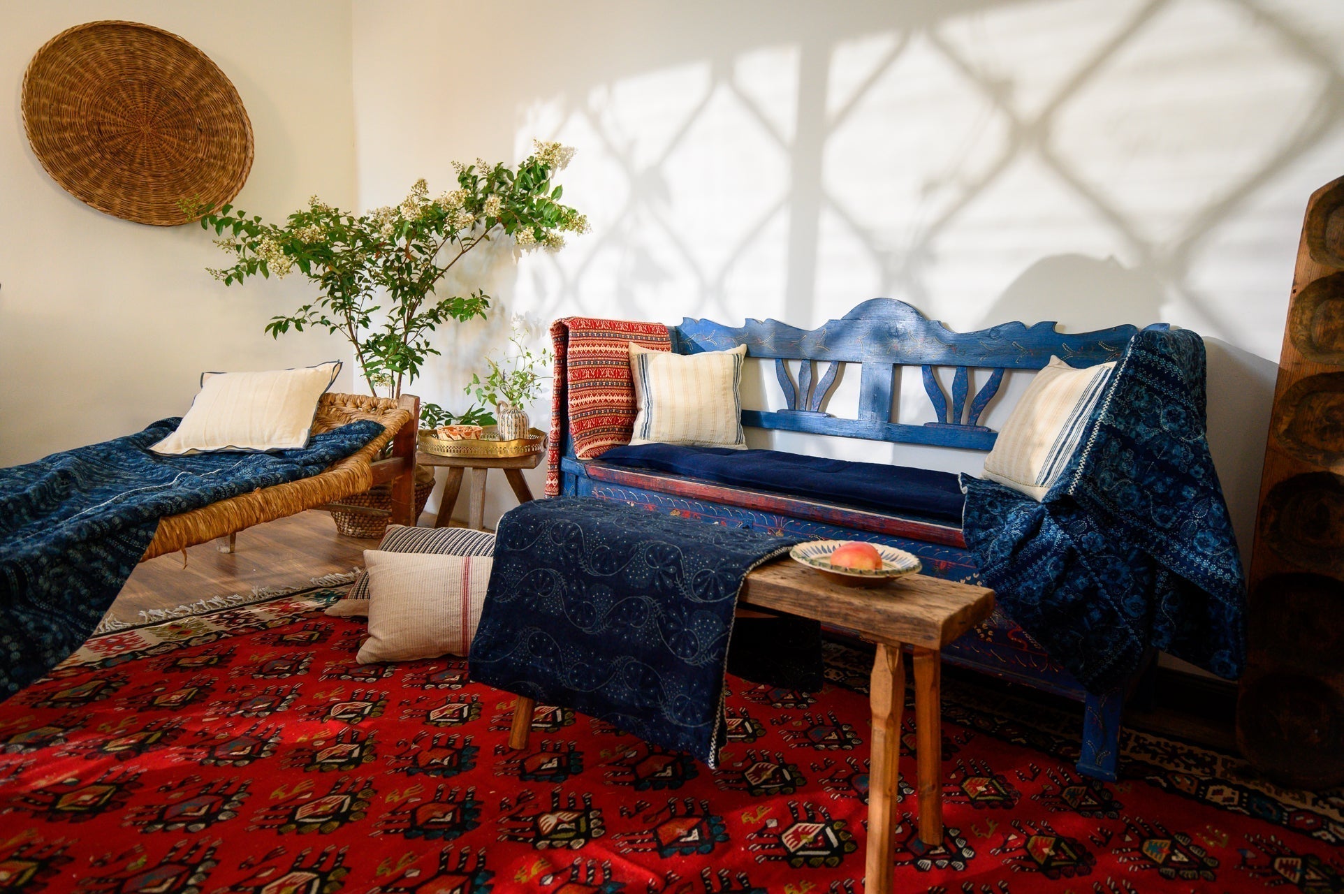 Handwoven antique hemp pillow in rustic home decor setting with blue bench and ethnic rugs.
