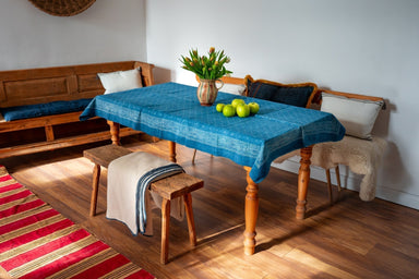 Antique handwoven Hungarian hemp table cloth with indigo wax resist pattern on wooden dining table.