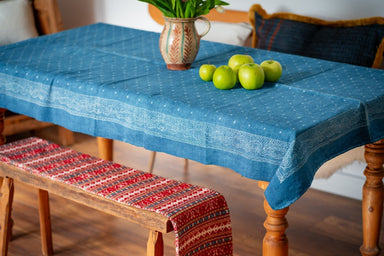 Antique handwoven Hungarian hemp table cloth with indigo dye on wooden table.