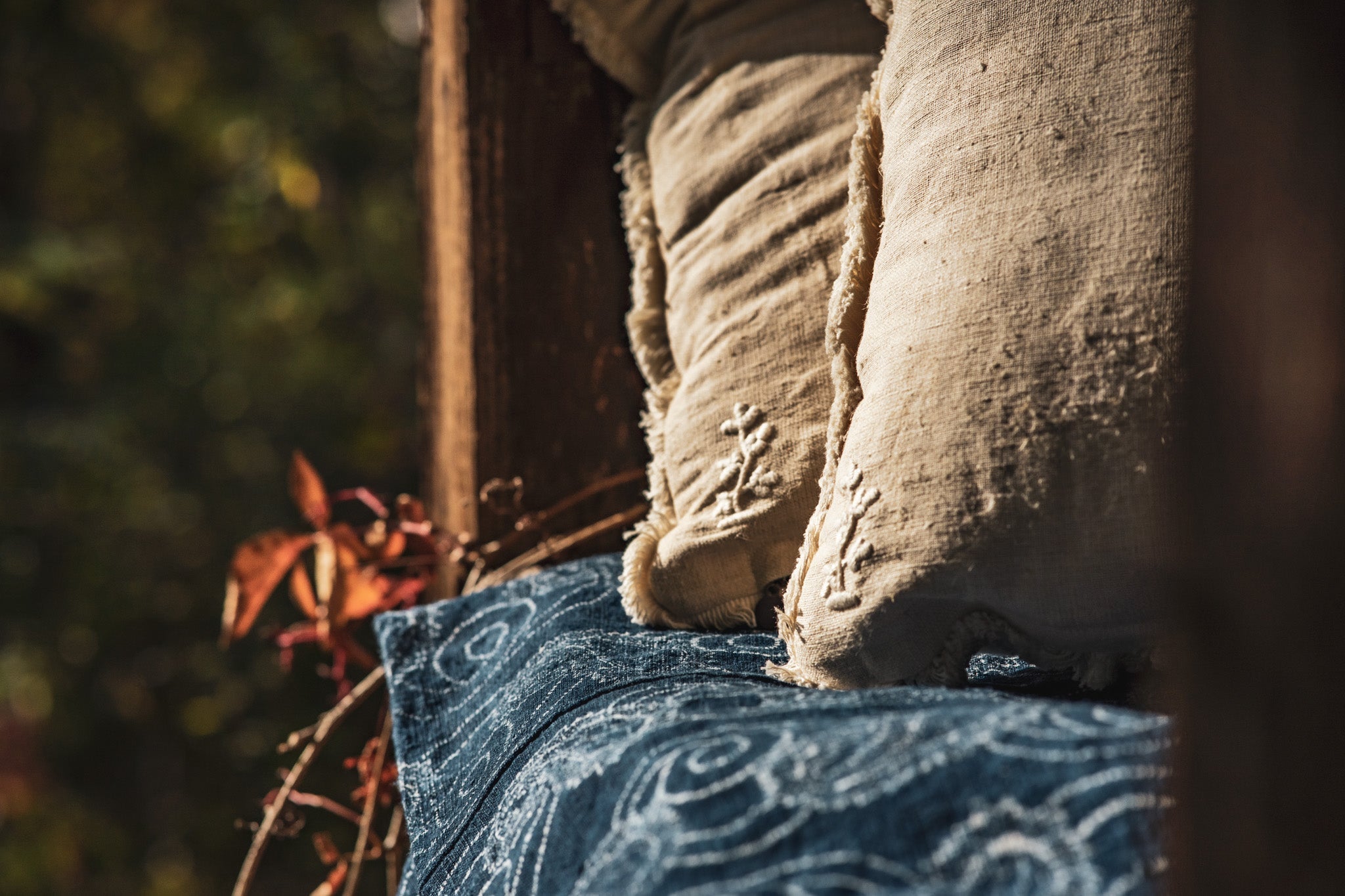 Handwoven antique Hungarian hemp pillow with rustic design on a wooden bench.