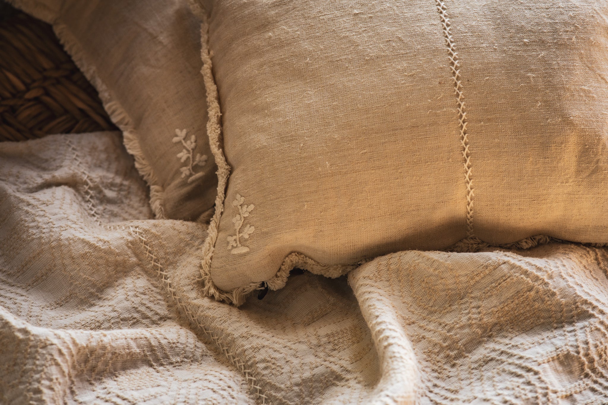 Handwoven antique Hungarian hemp pillow on textured fabric.