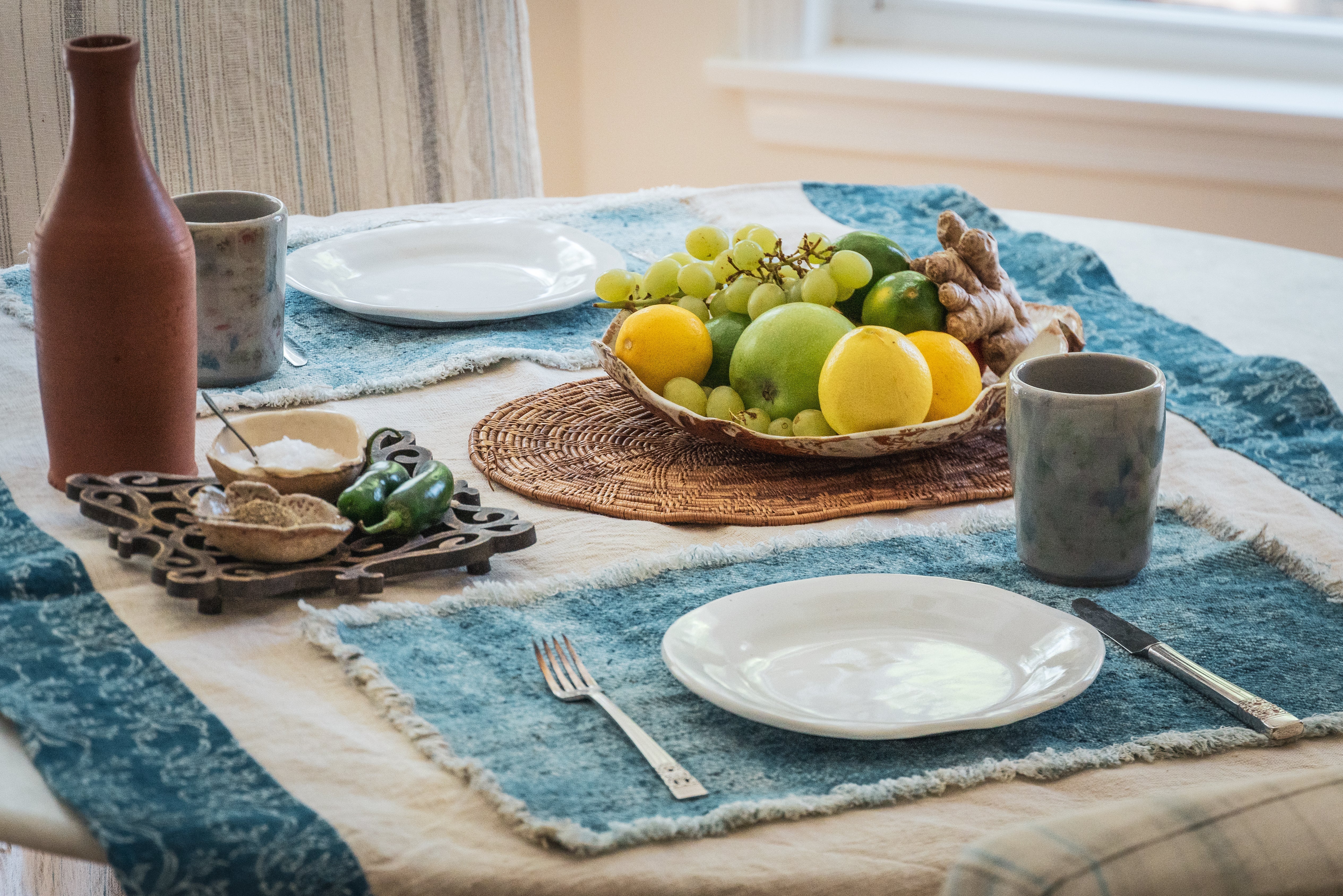 Antique handwoven Hungarian hemp table runner with natural and indigo pattern on dining table.