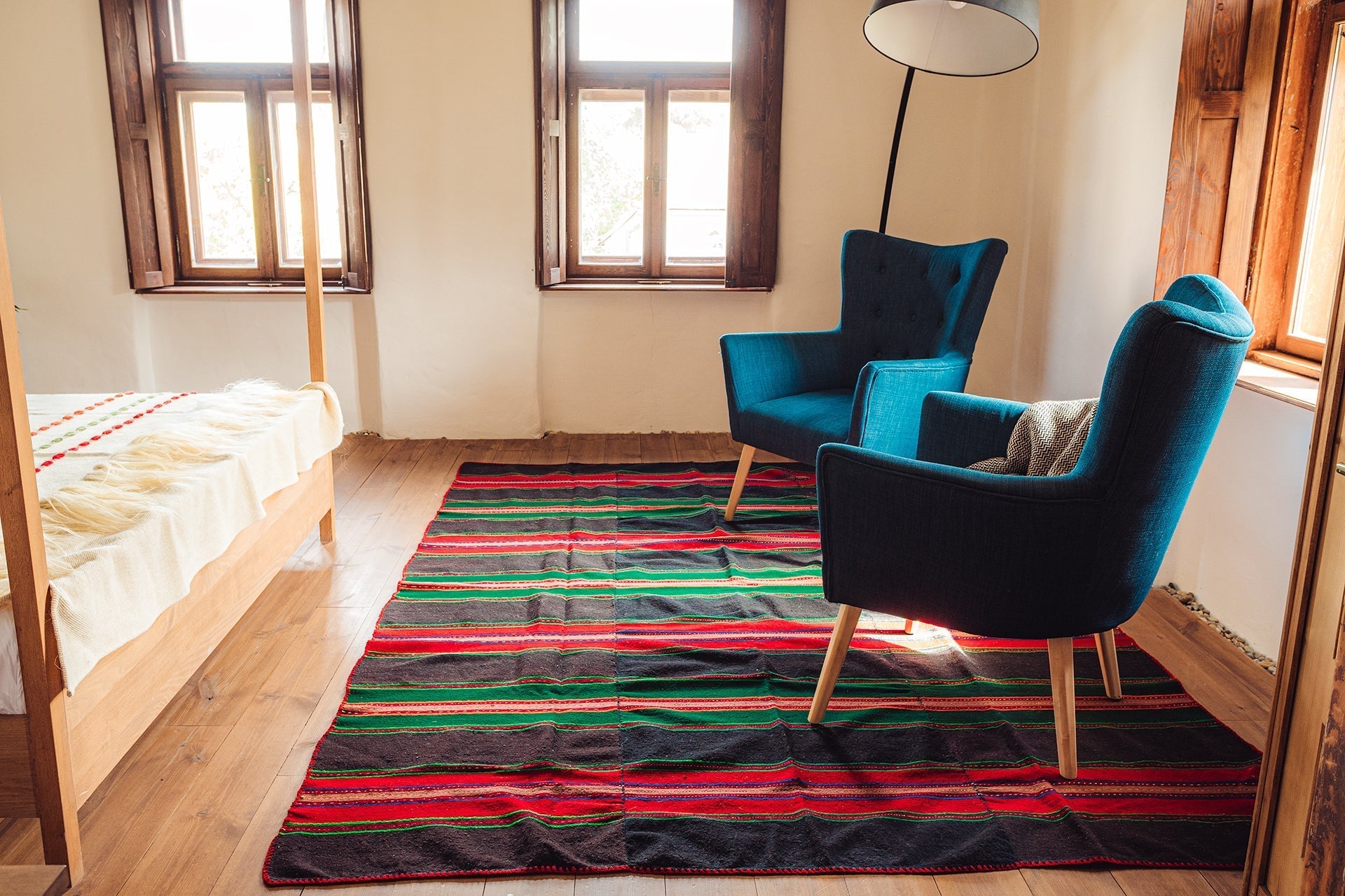Antique handwoven Bulgarian wool rug with colorful stripes, 210x260 cm, in a cozy room setting.