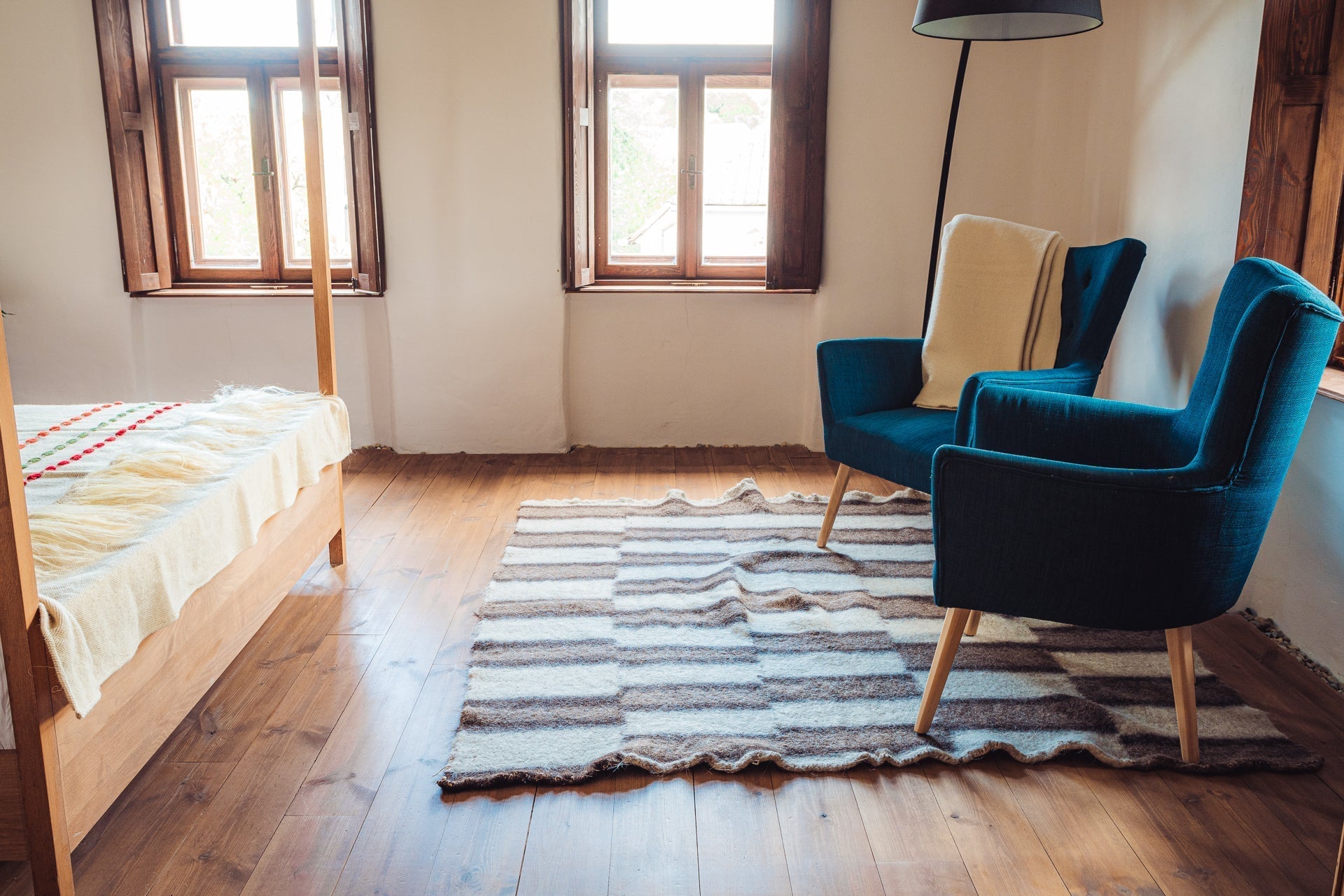 Antique handwoven rug from Bulgaria, natural wool colors, 180x200 cm, in a rustic room setting.