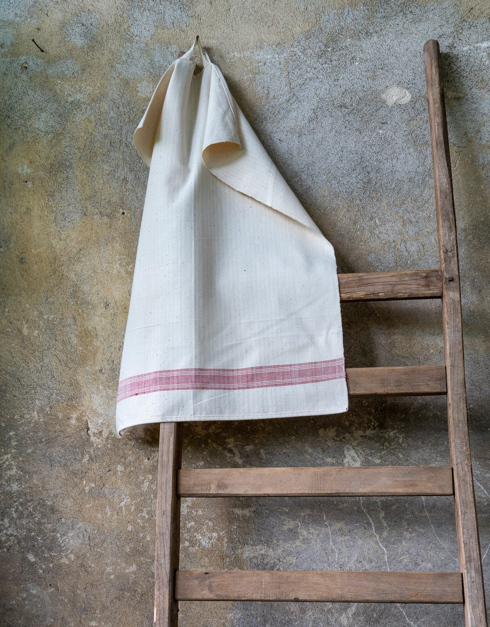 Handwoven antique Hungarian cotton towel on wooden ladder.