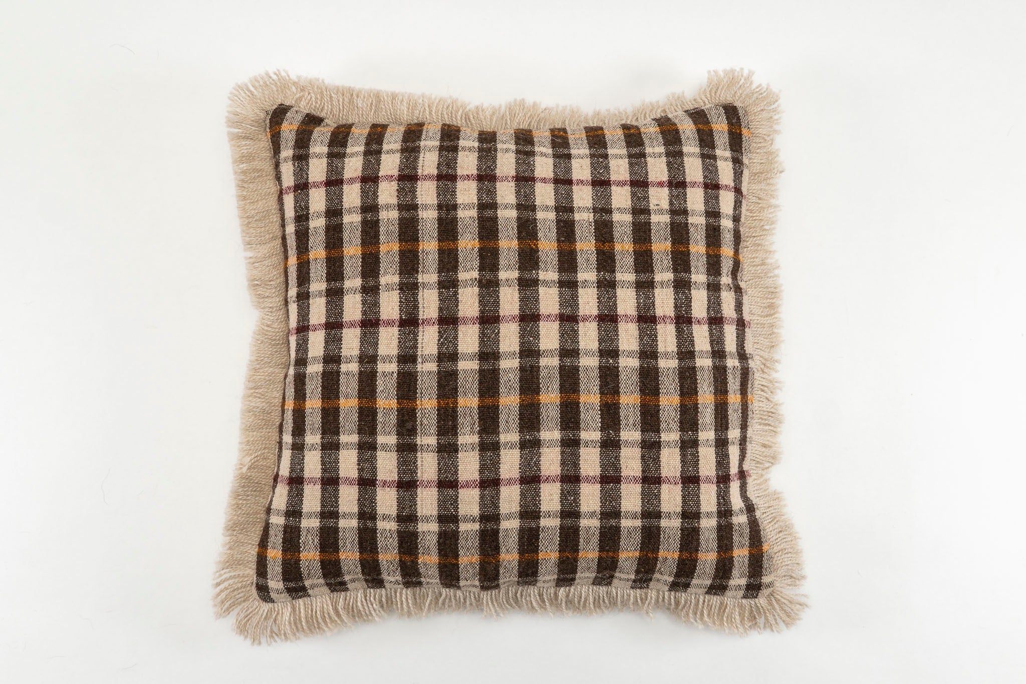 Handwoven antique Bulgarian woolen pillow with fringe and plaid design.