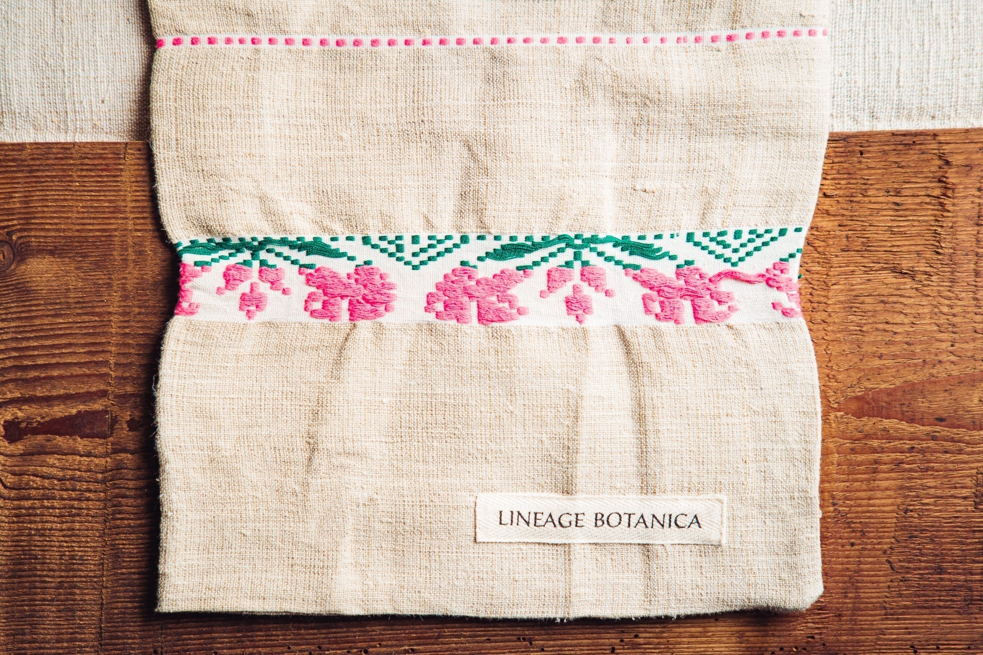 Handwoven antique hemp bread bag with pink and green embroidery details.