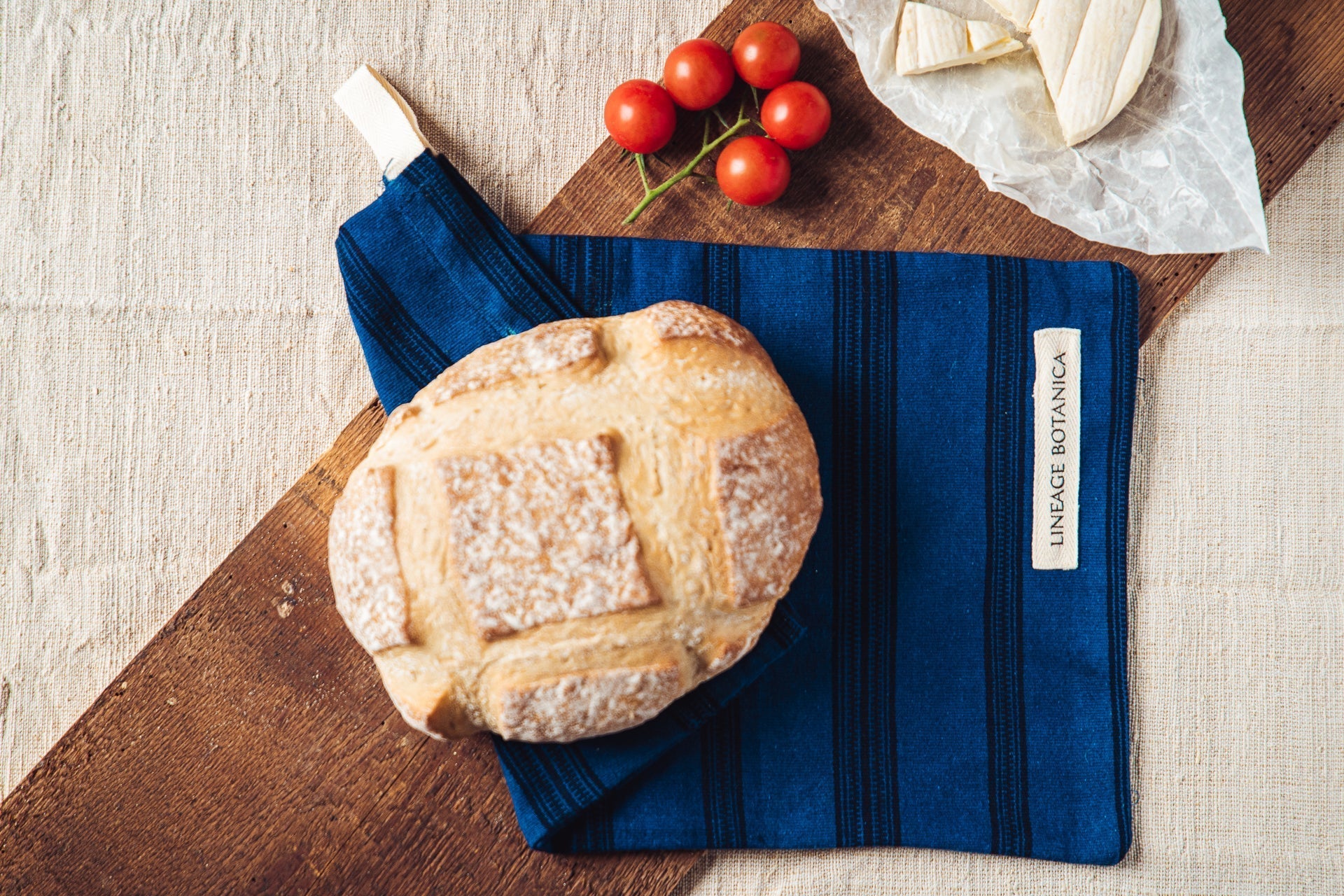 Handwoven antique and vintage hemp bread bag with bread and tomatoes.