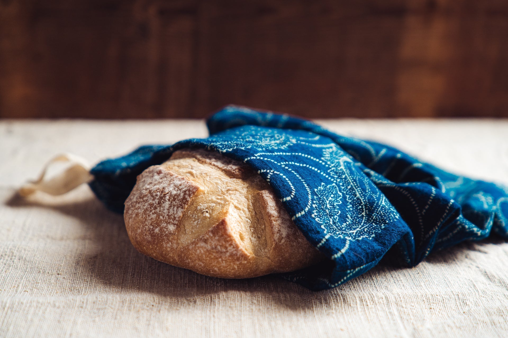 Handwoven antique bread bag with loaf of bread inside, dyed indigo by Sárdi János Kekfesto, Hungary.