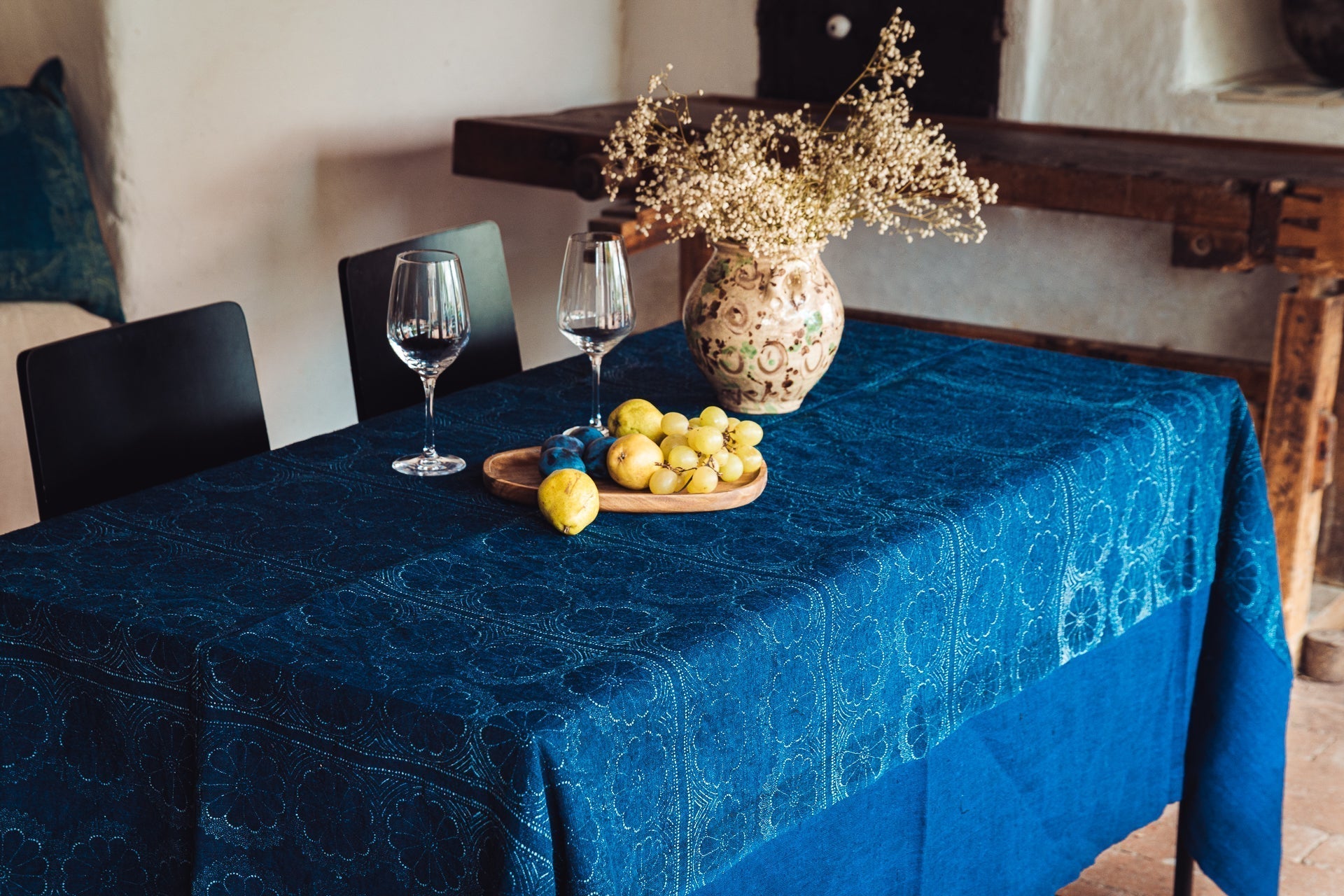 Antique handwoven Hungarian hemp table cloth with indigo dye on dining table.