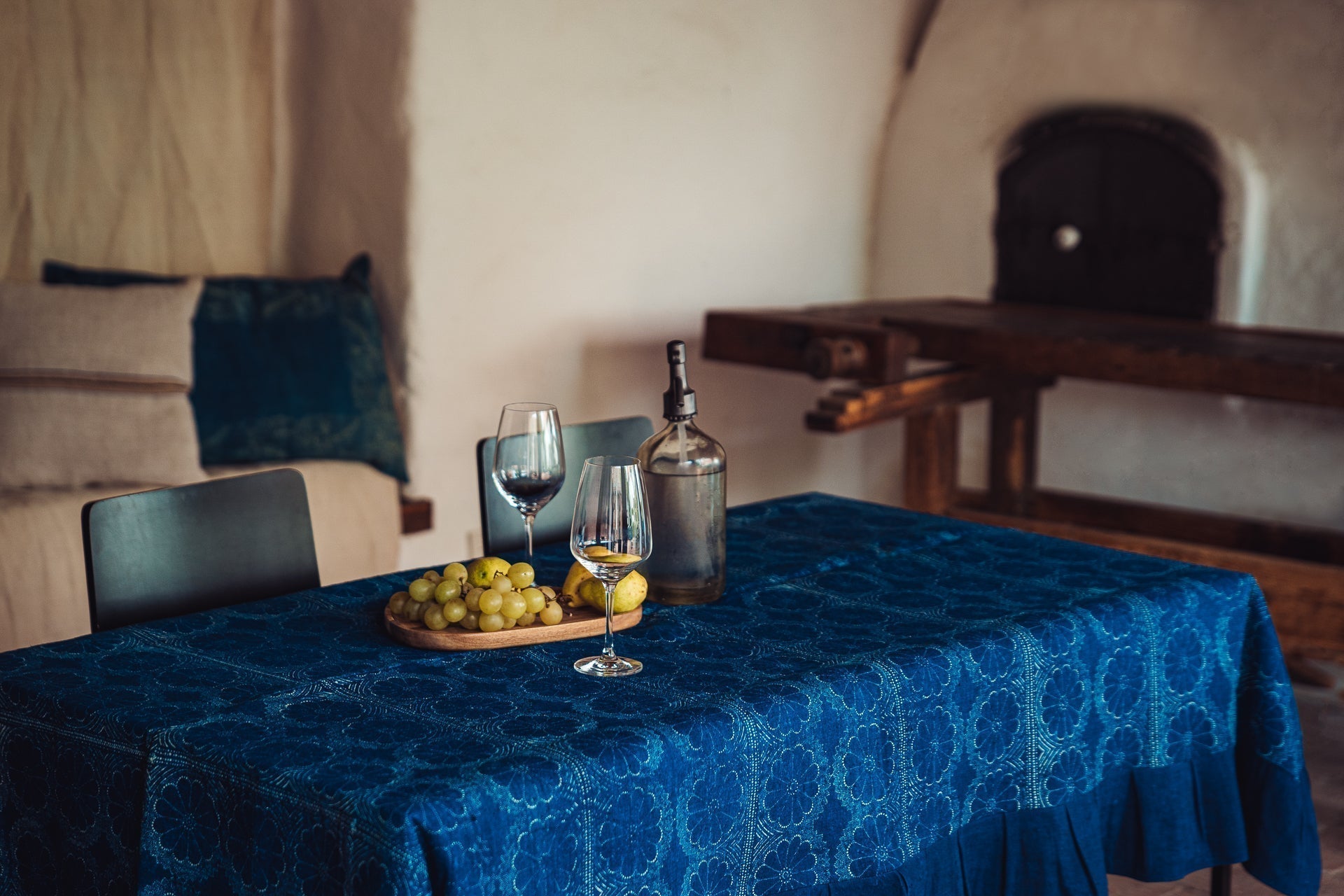Antique handwoven Hungarian hemp table cloth with indigo dye and wax resist design on a dining table.