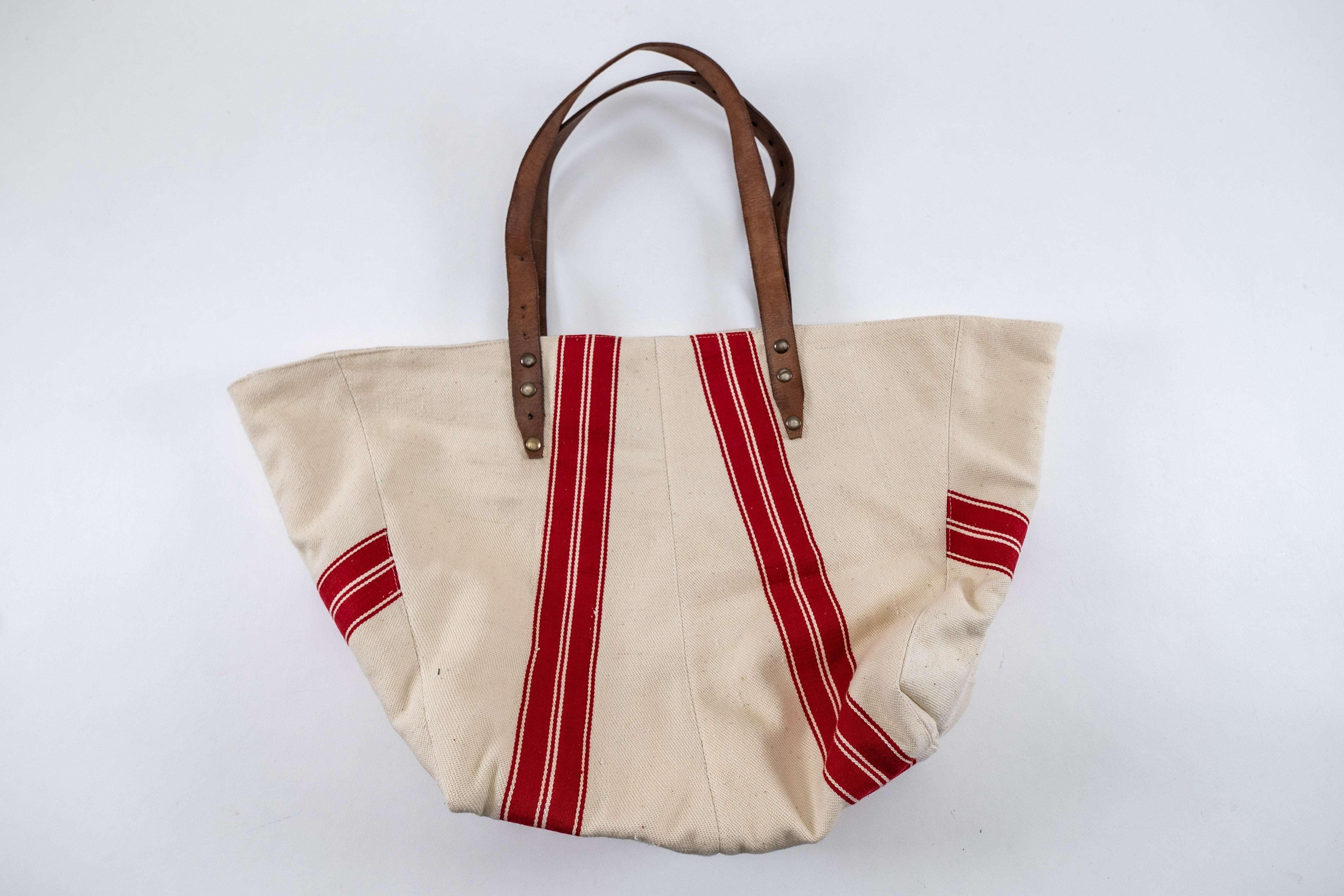 Handwoven antique Hungarian hemp bag with red stripes and leather handles.
