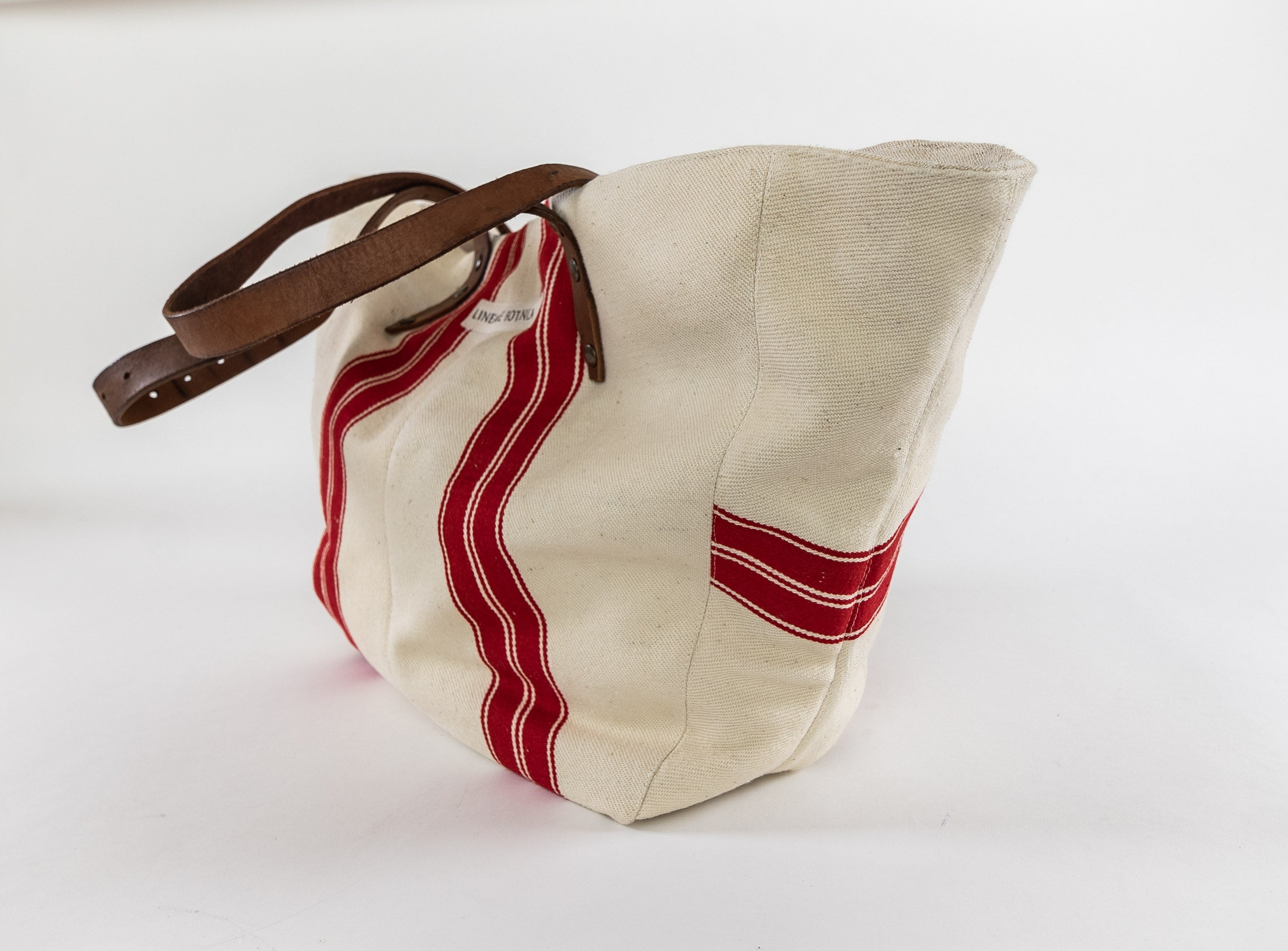 Handwoven antique Hungarian hemp bag with red stripes and leather handle.