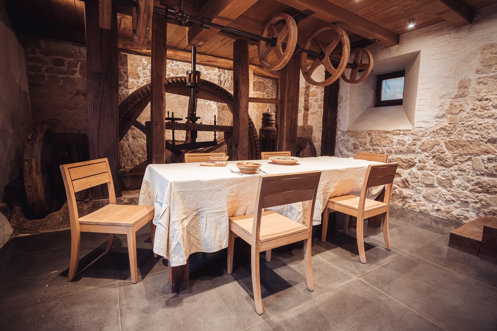 Handwoven organic cotton table cloth from India displayed on dining table in rustic setting.