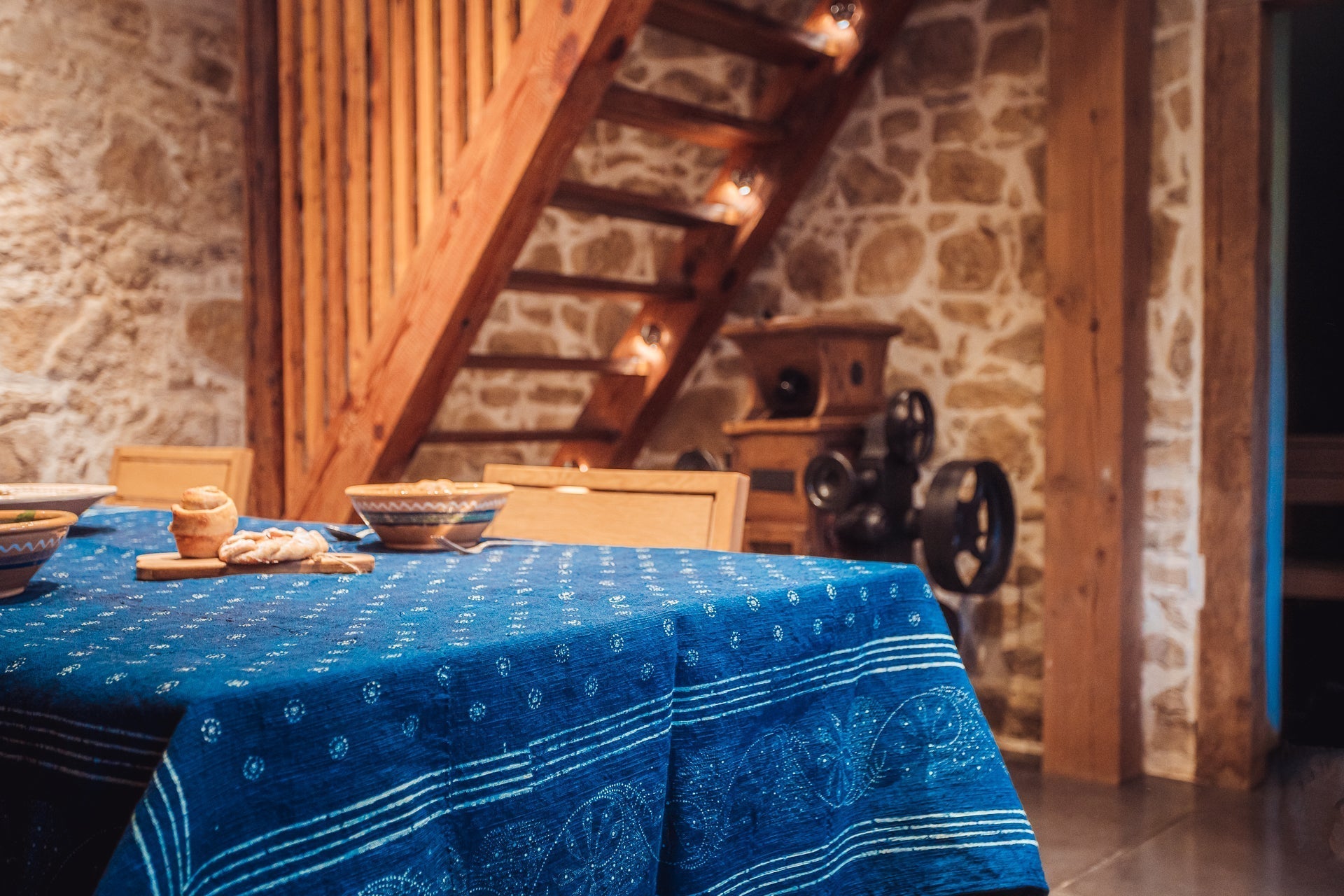 Antique handwoven Hungarian hemp table cloth with indigo wax resist design in rustic interior.