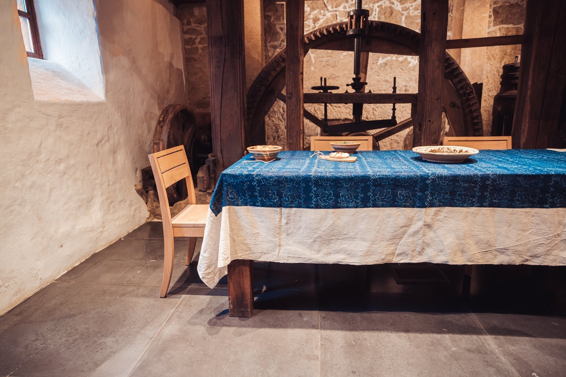 Antique handwoven Hungarian hemp table cloth with indigo over dye, displayed on a rustic dining table.