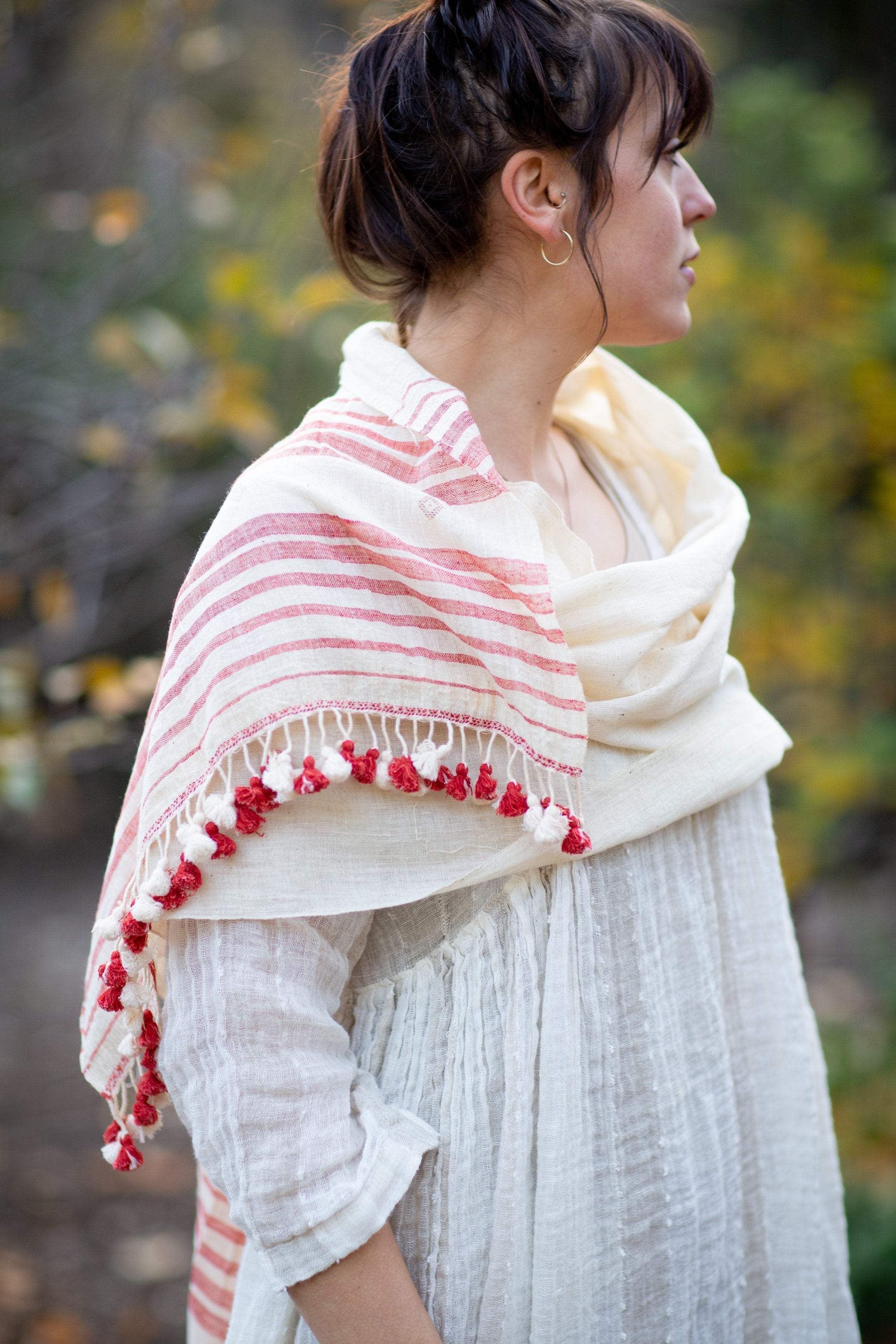 Handwoven organic Kala cotton shawl in natural tones with red accents, crafted by artisans in Kutch, India.