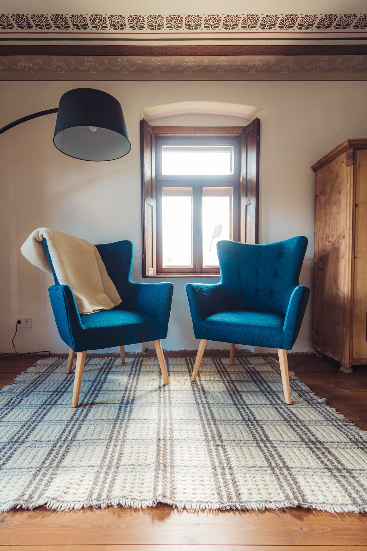 Handwoven Merino wool throw on blue armchair in cozy room setting.