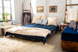 Organic hemp bed cover with handwoven, indigo-dyed design in cozy bedroom setting.