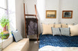 Handwoven organic hemp bed cover in indigo with vintage decor in a cozy room setting.