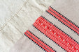 Organic handwoven hemp bed cover with red and black pattern detailing.