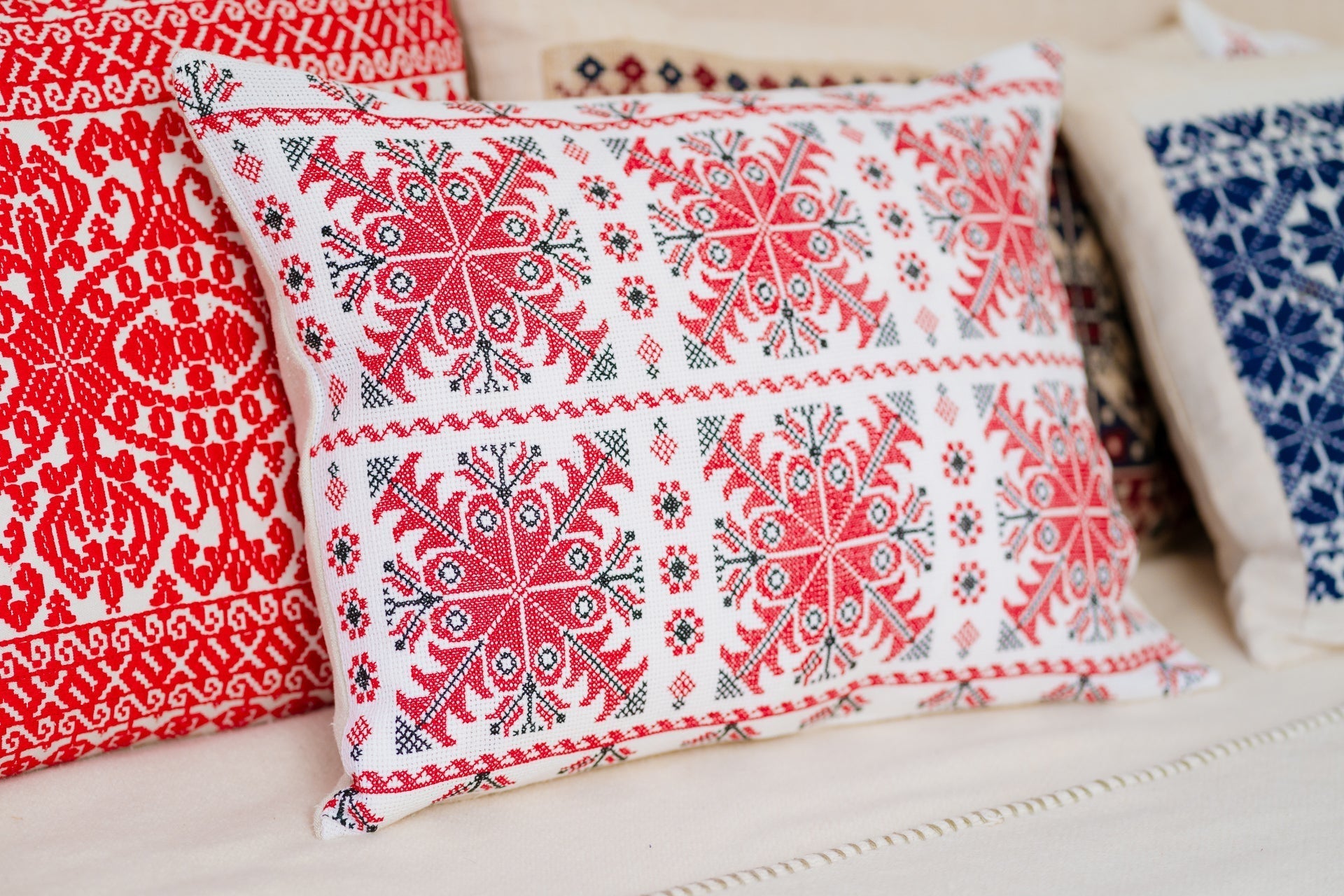 Embroidered handwoven antique Hungarian hemp pillow with red geometric patterns.