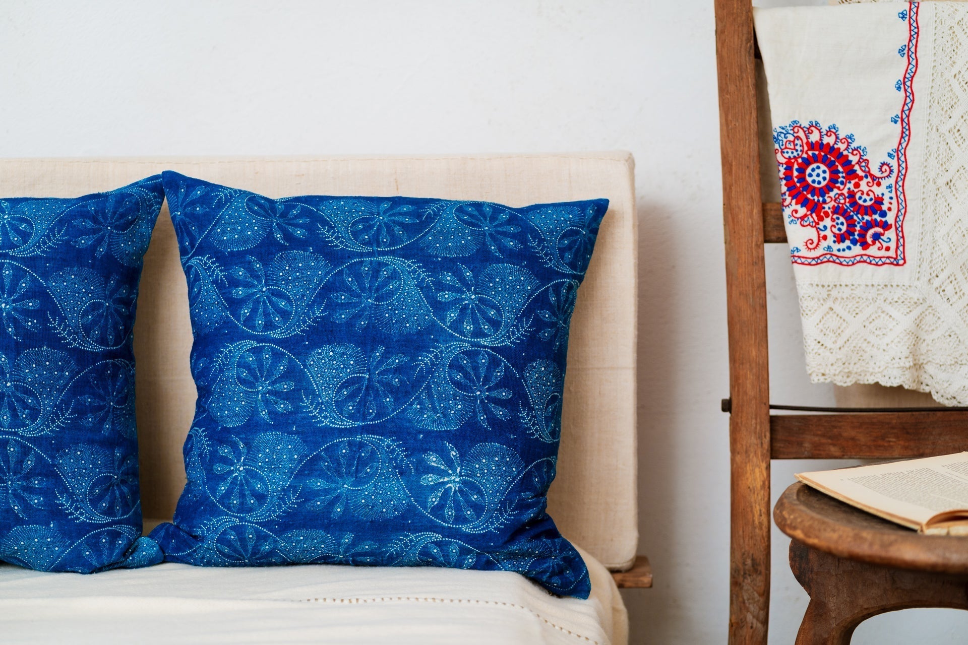 Handwoven antique Hungarian hemp pillow in wax resist indigo design on sofa.