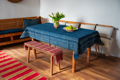 Antique handwoven Hungarian hemp table cloth with indigo dye on a wooden table.