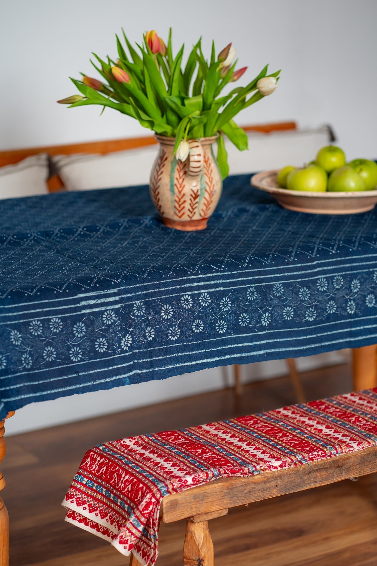 Antique handwoven Hungarian hemp table cloth with indigo wax resist design on a wooden table.