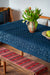 Antique handwoven Hungarian hemp table cloth with indigo wax resist design, displayed on a wooden table.