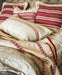 antique Hungarian hemp throw with red embroidery and eco-cotton backing on bed with matching pillows