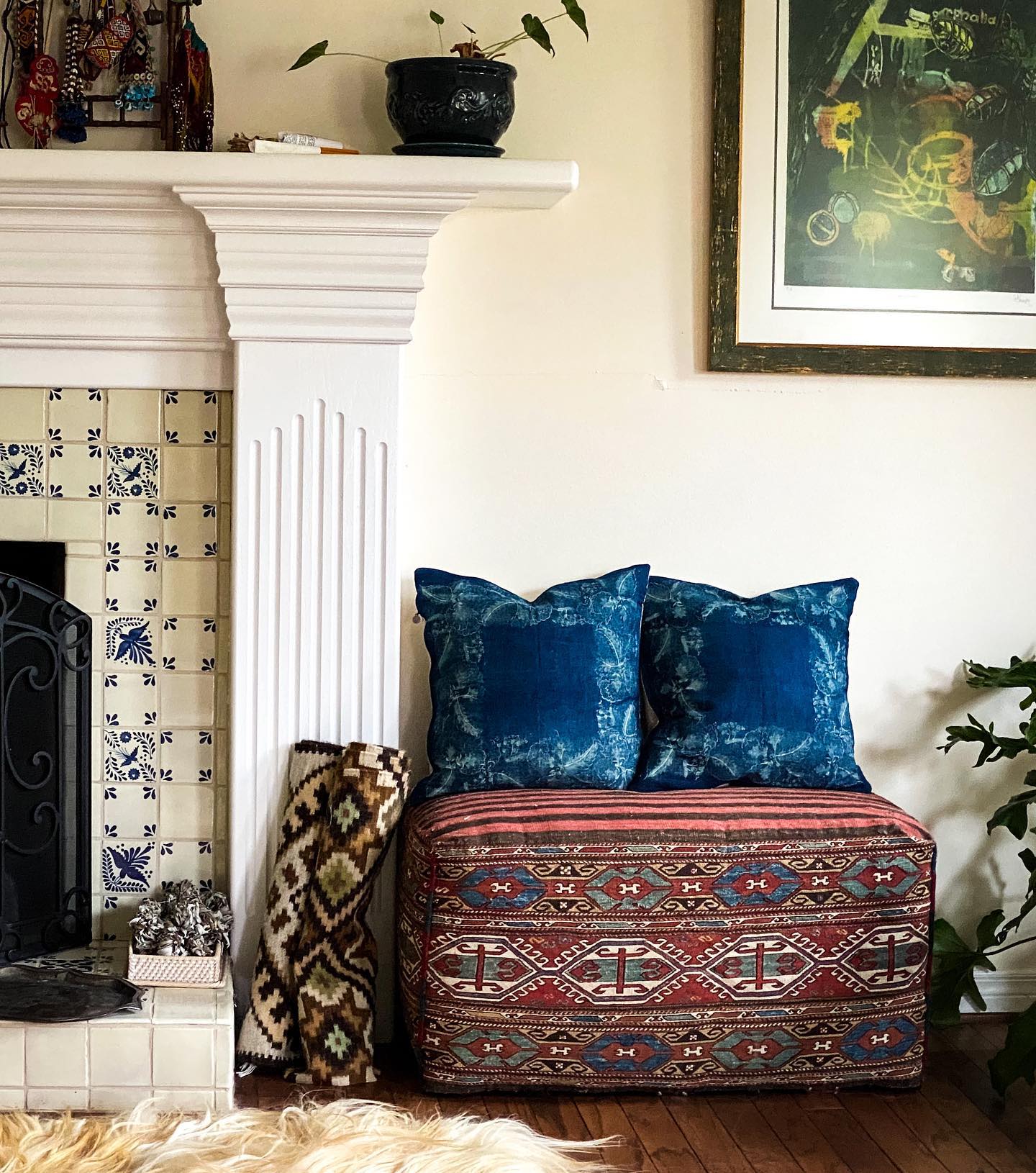 Handwoven antique Hungarian hemp pillows in indigo dye on a patterned seat near a fireplace.