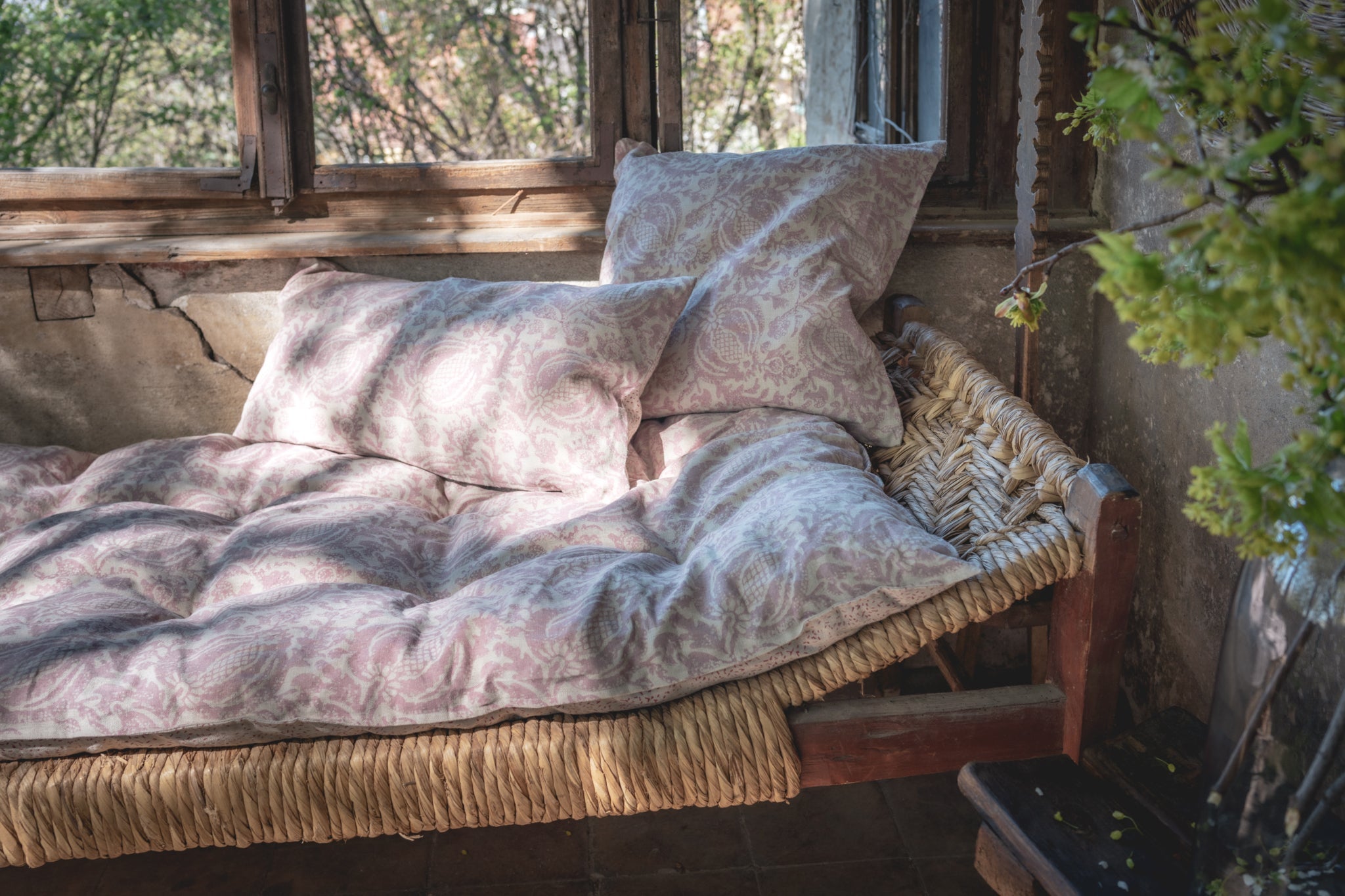 Hand printed linen pillow on rustic bench with cozy natural setting.