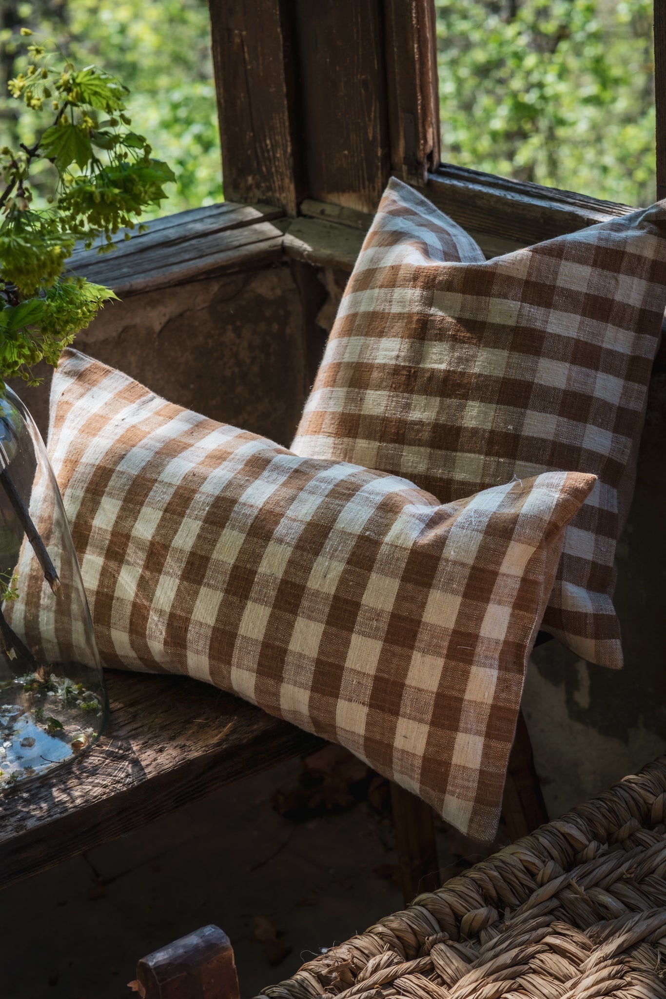 Handwoven organic cotton pillow with natural dye, on rustic chair.