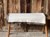 Organic eco cotton blanket on a wooden bench, featuring soft natural fibers and sustainable design.