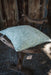 Hand block printed linen pillow with heritage design on rustic chair.