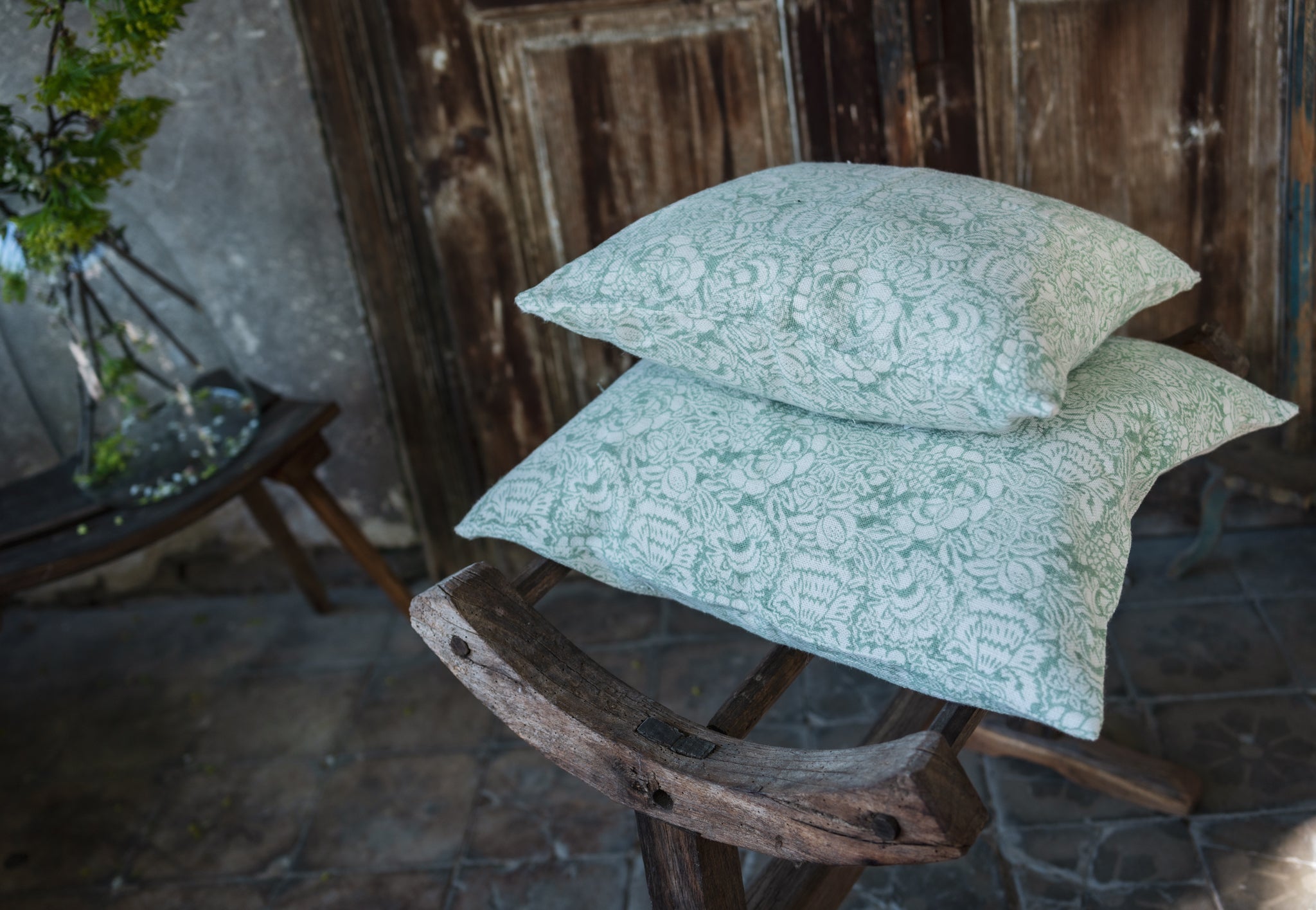 Hand block printed linen pillow with heritage design on decorative chair.