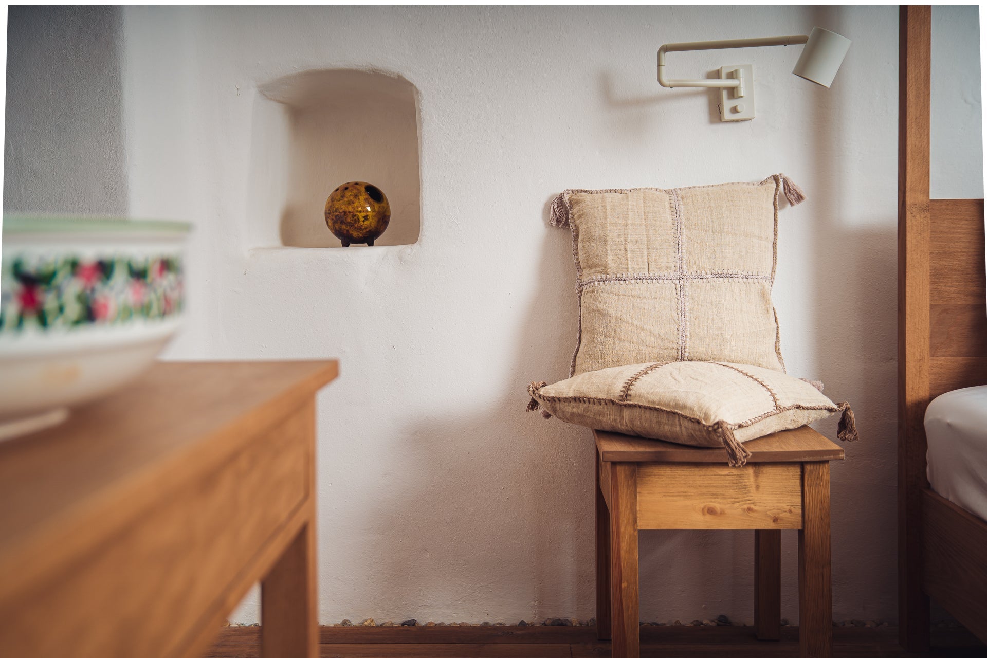 Antique Hungarian handwoven hemp pillow with mauve and taupe stitching on a wooden chair.