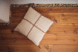 Antique Hungarian handwoven hemp pillow with taupe threads on wooden floor.