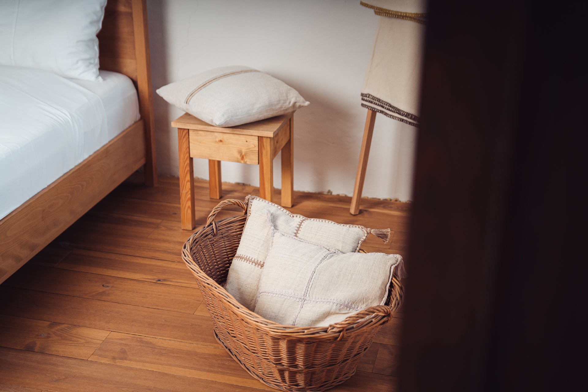 Antique Hungarian handwoven hemp pillow with hand stitching on wooden stool; sustainable home decor.