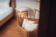 Pillow made from antique Hungarian handwoven hemp with taupe stitching, displayed in a cozy bedroom.
