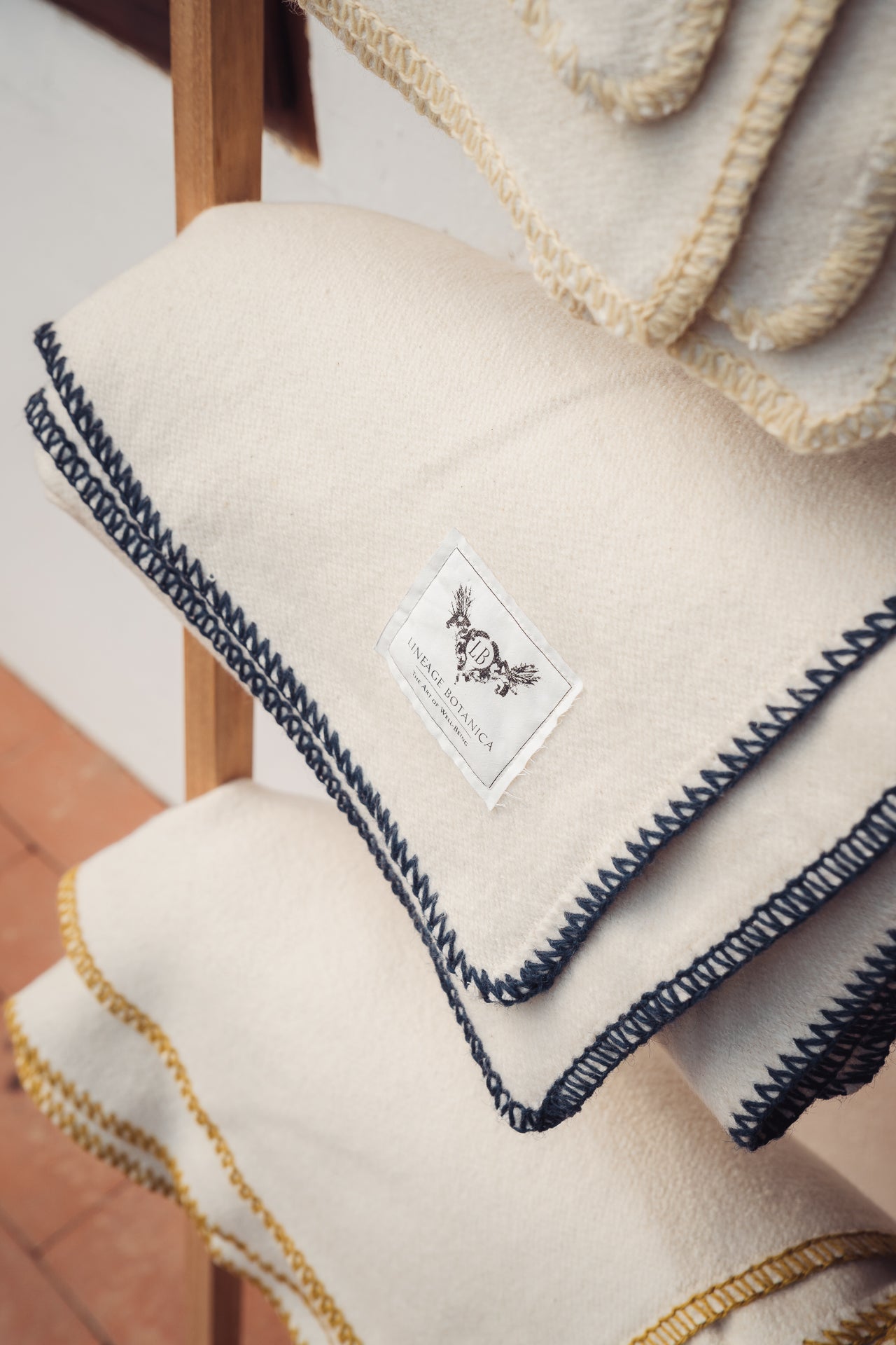 Organic eco-cotton blanket with indigo trim, woven in Bulgaria, featuring hand-stitched border.