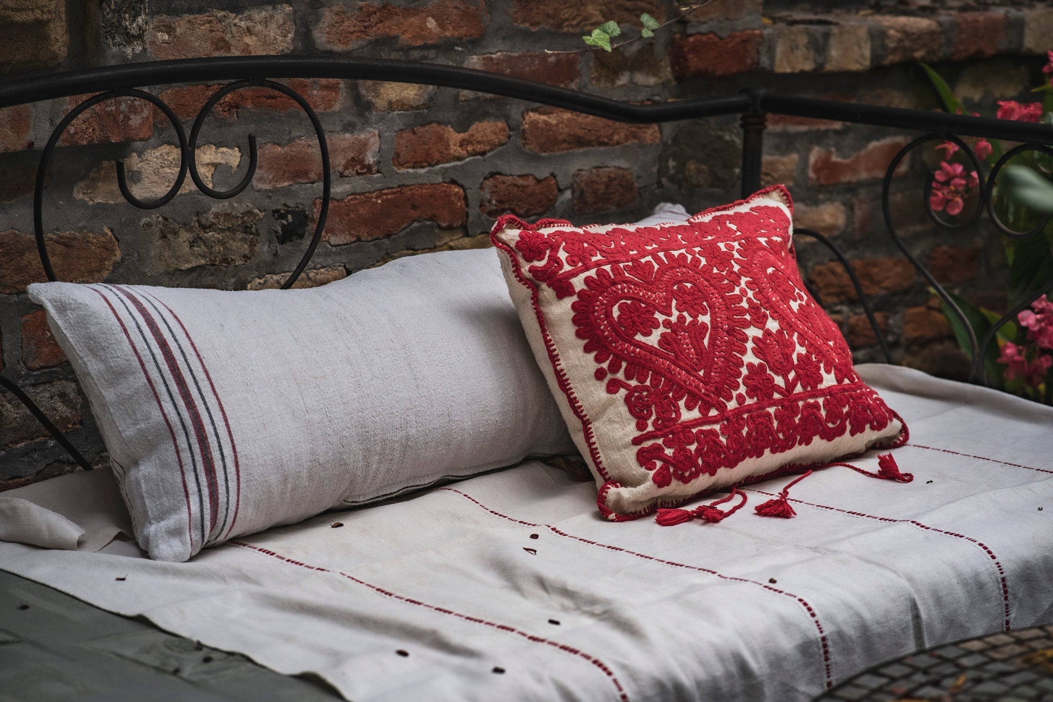 Grain sack handwoven Hungarian hemp pillow with vintage design on rustic bench.