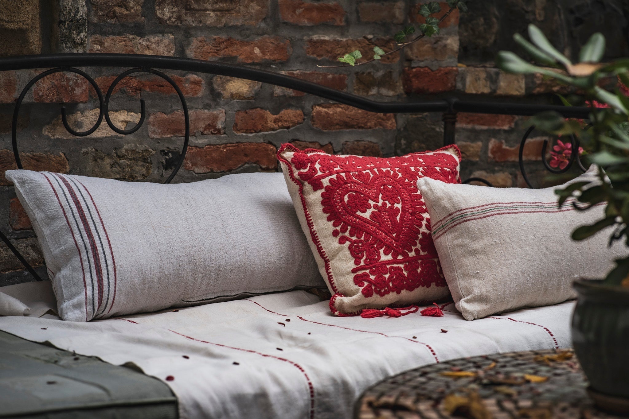 Pillow made from grain sack handwoven Hungarian hemp displayed on a rustic bench.