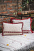 Embroidered antique handwoven Hungarian hemp pillow with red fringe.