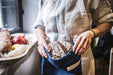 Handwoven antique baguette bread bag in use, showcasing indigo dye and vintage hemp fabric.