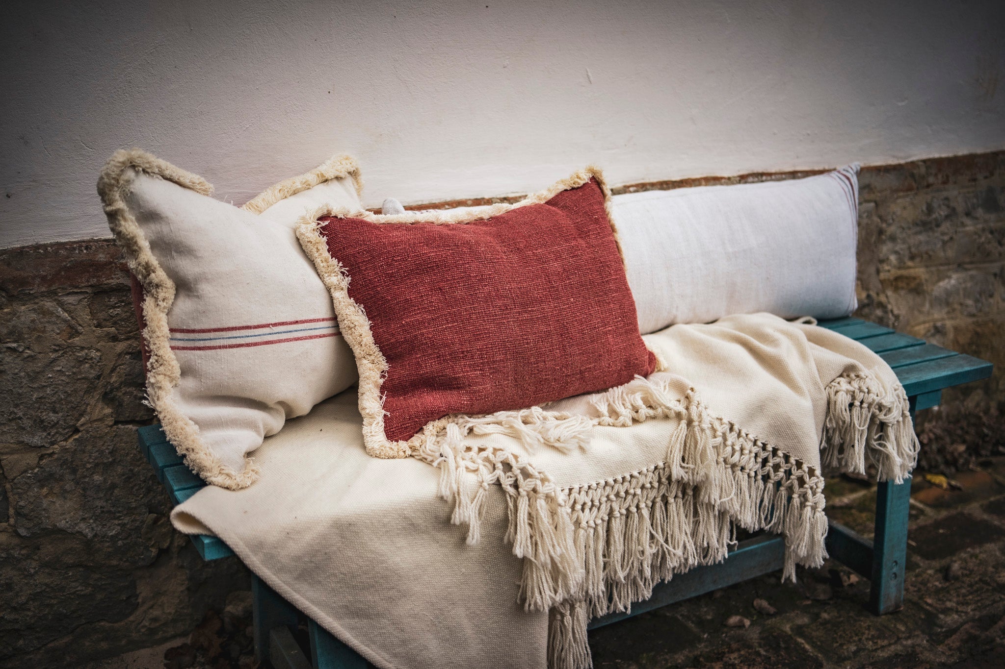 Handwoven antique Hungarian hemp pillow with red back and cotton fringe.