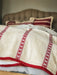 antique Hungarian hemp throw with red embroidered stripes and fringe on bed
