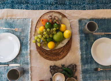 Antique handwoven Hungarian hemp table runner with natural and indigo pattern, styled with fruit and place settings.