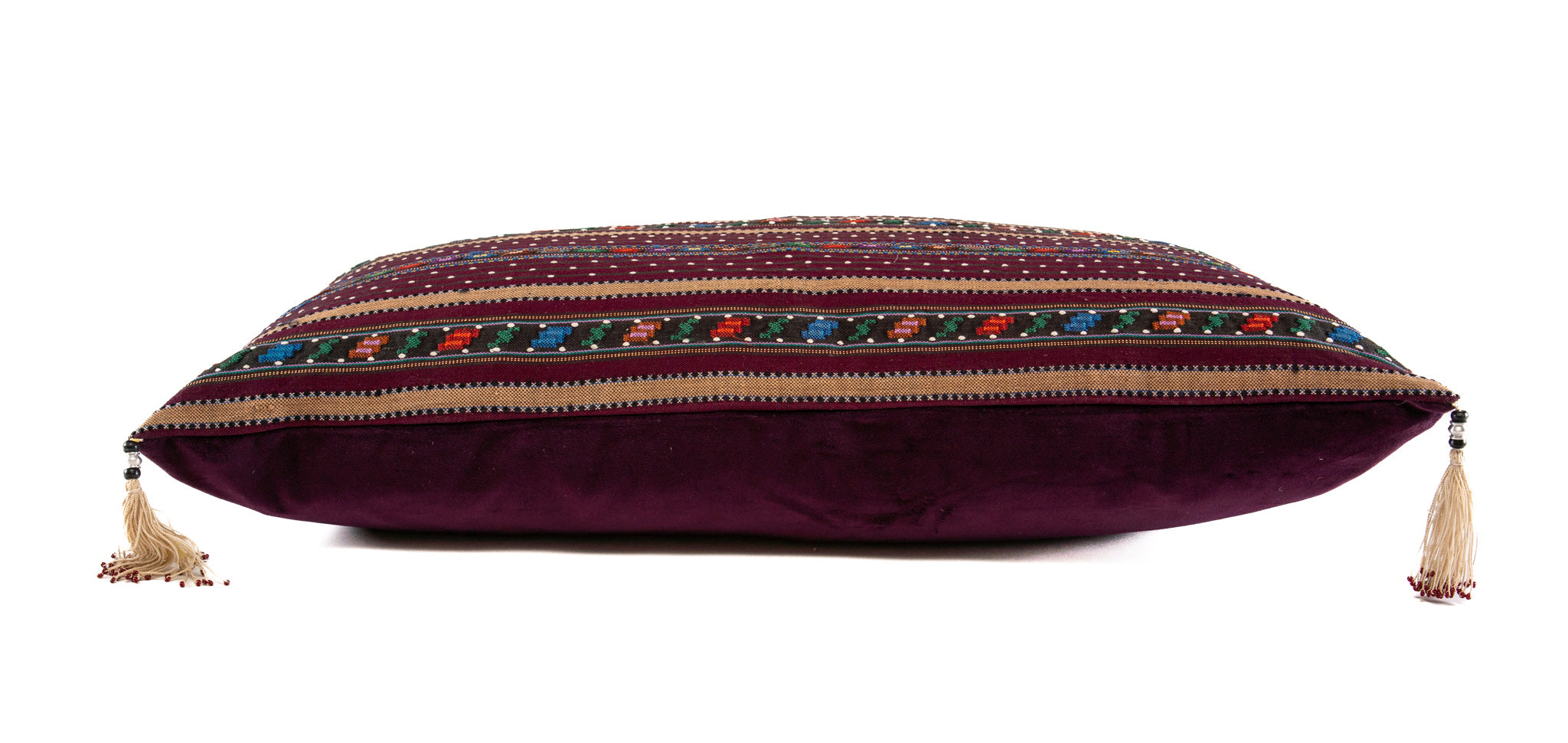 Handwoven Romanian artifact textile pillow with colorful patterns and tassels.